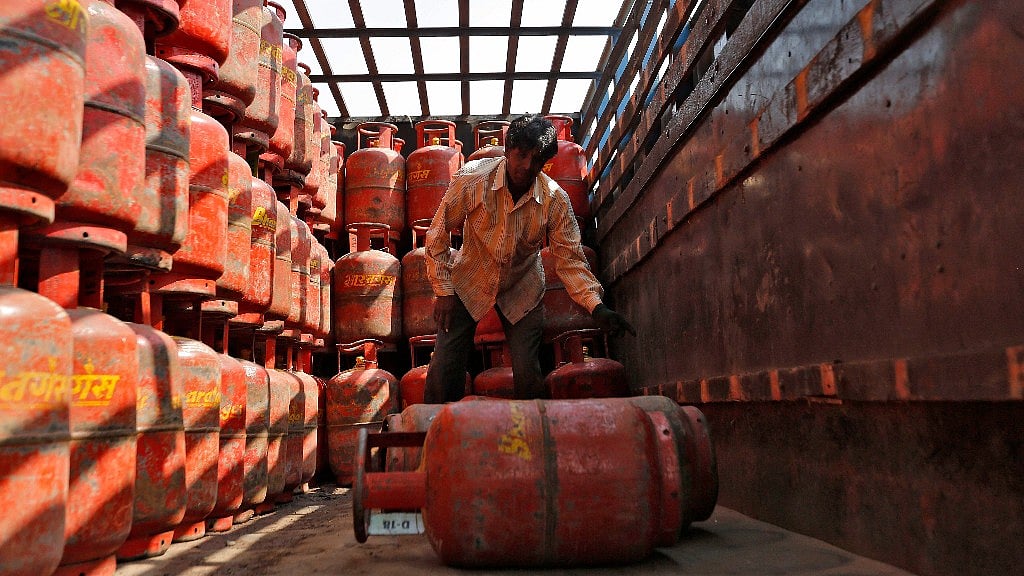 A worker unloads LPG cooking cylinders from a supply truck outside a distribution centre. Image used for representation.