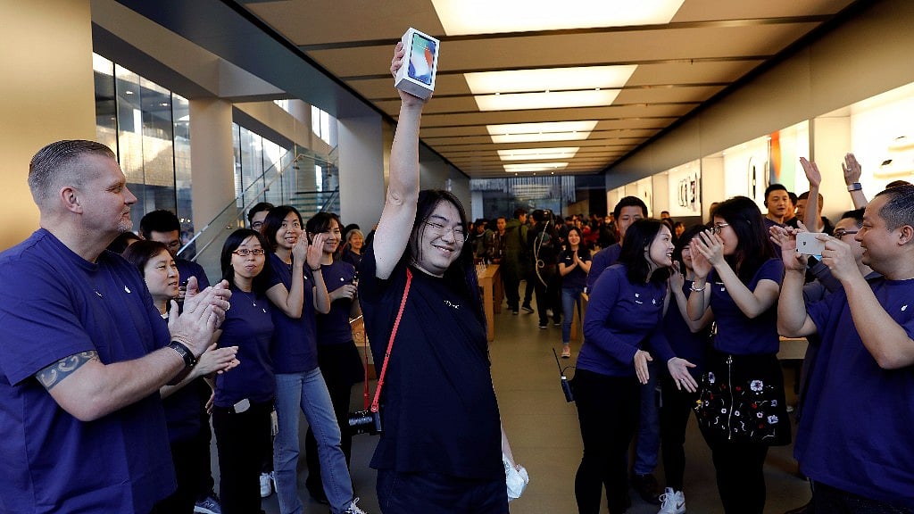 One of the first customers shows off the new iPhone X after buying it at an Apple Store in Beijing.