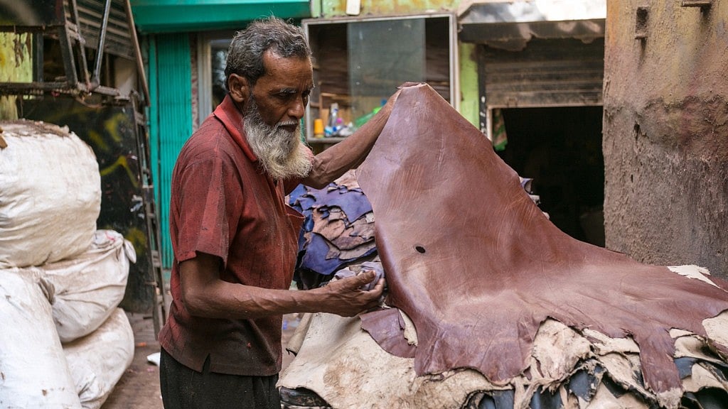 Man handling leather sheets. 