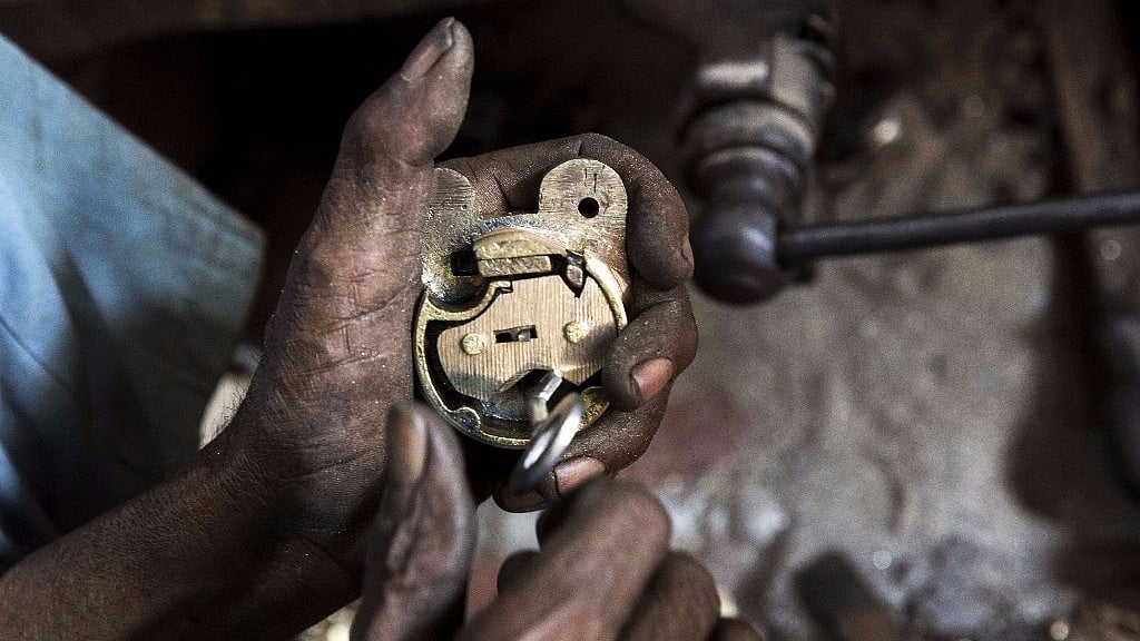 A worker manufactures a lock at a workshop in Aligarh, Uttar Pradesh, India. 