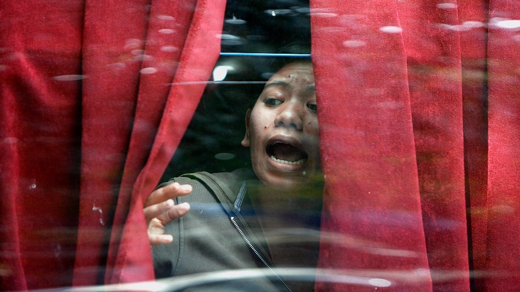 A trapped guest looks out of the window from the Taj Mahal Hotel in an attempt to find help.