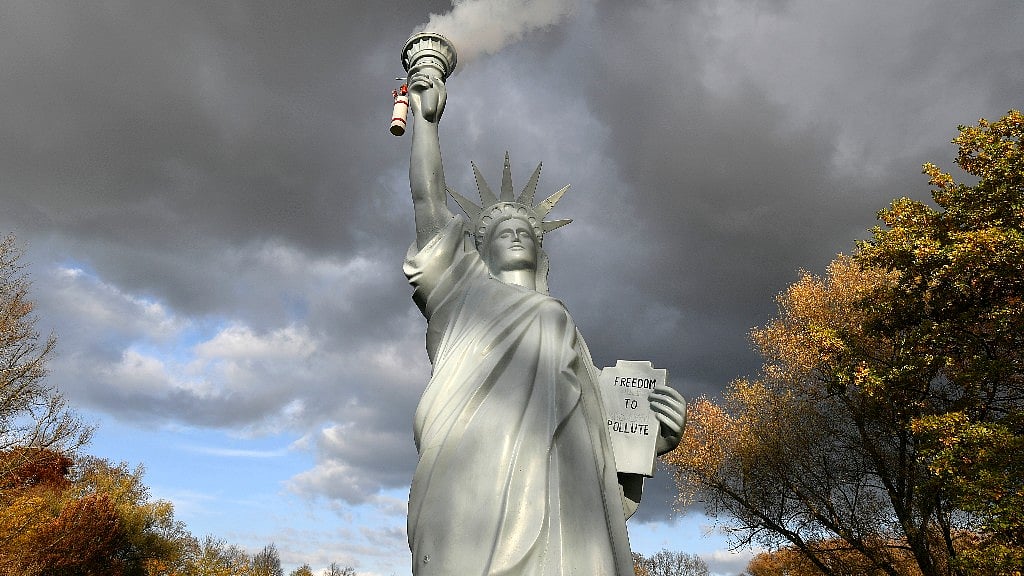 A replica of the Statue of Liberty emits smoke in a park outside the 23rd UN Conference of the Parties climate talks in Bonn, Germany, 17 November, 2017.