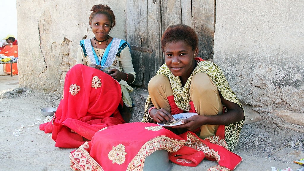 Girls from Siddi community working on embroidery of a fabric.