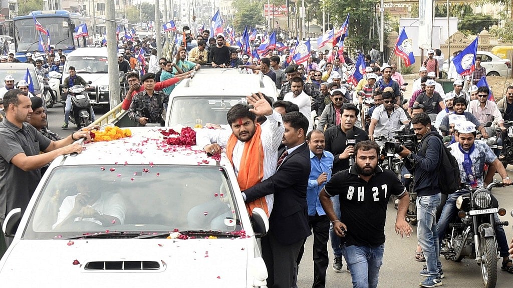 Patidar Anamat Andolan Samiti (PAAS) leader Hardik Patel waves at supporters during a roadshow for the second phase of Gujarat elections in Ahmedabad.