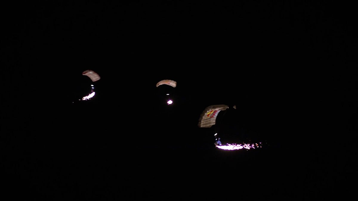 Skydivers attach fireworks to wingsuits