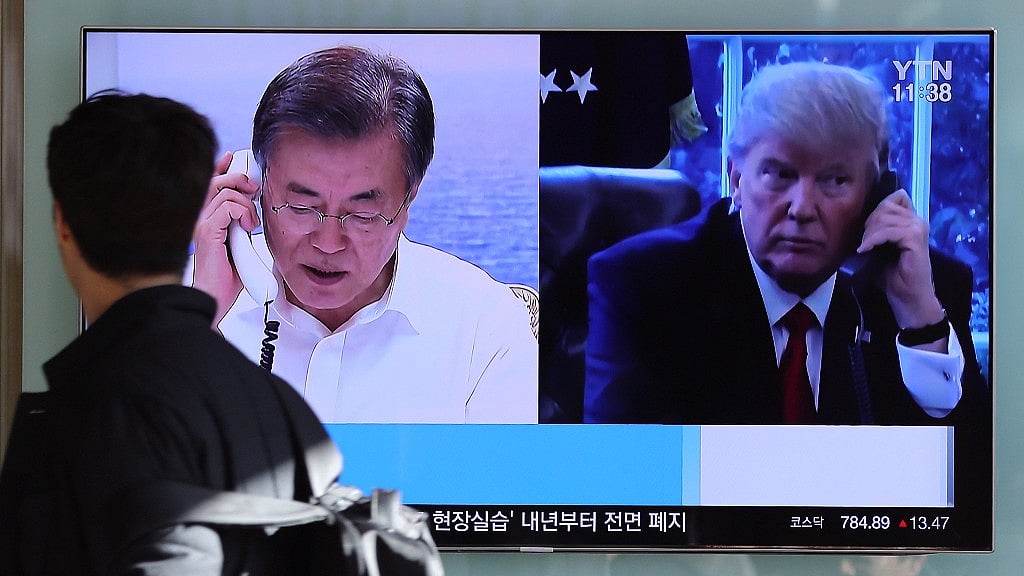 A man walks by a TV screen showing a local news program reporting about North Korea’s missile launch with an images of US President Donald Trump and South Korean President Moon Jae-in at the Seoul Railway Station in Seoul, South Korea.