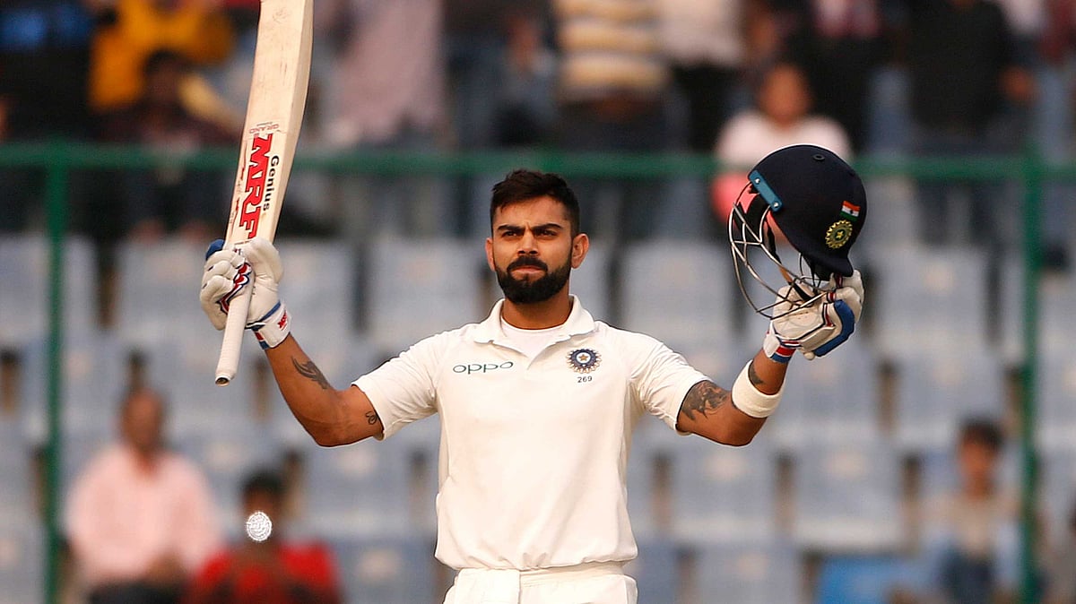Virat Kohli lifts his bat after completing his century at Kotla.