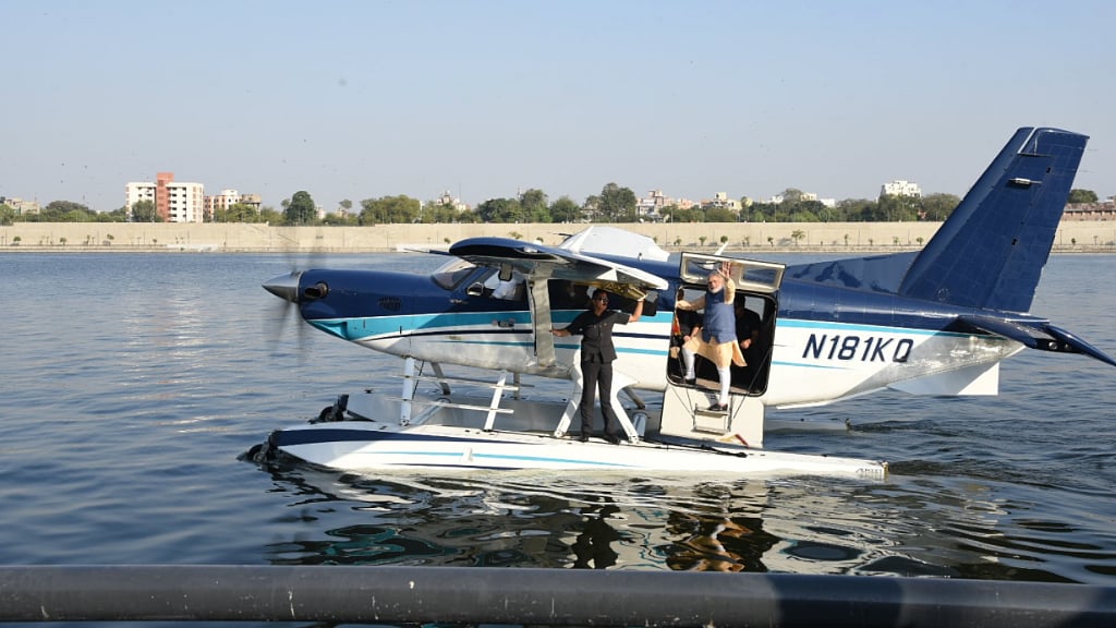 Prime Minister Narendra Modi waves to the crowd as he boards a seaplane on the Sabarmati river front in Ahmedabad on Tuesday.