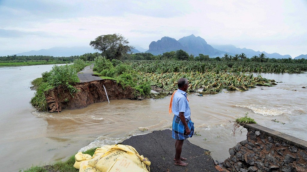 A man looks at one of the many roads damaged by Cyclone Ockhi.