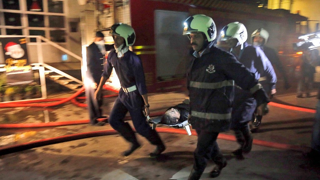Firemen carry an injured person after a fire broke out in a building in Mumbai. 
