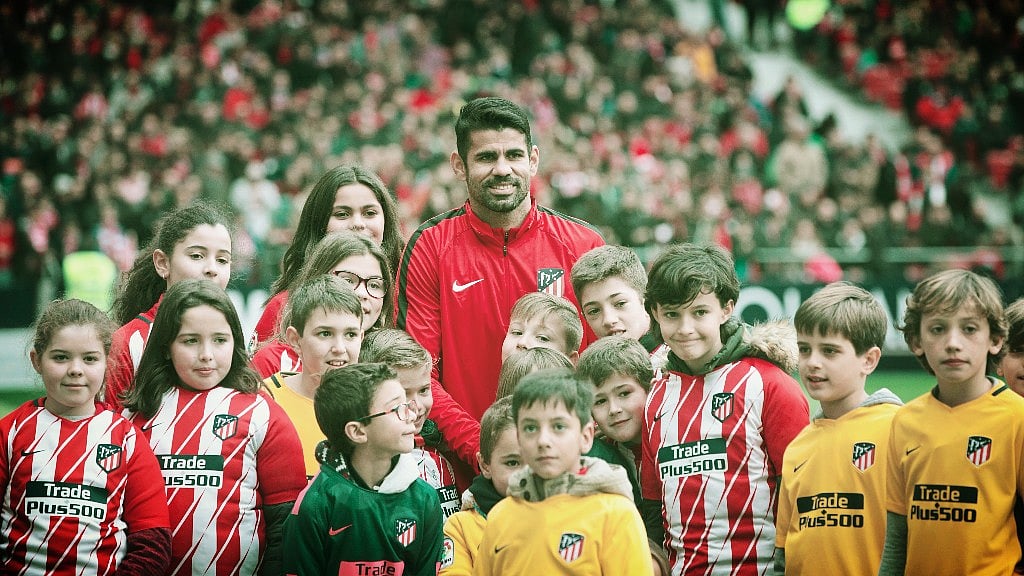 Diego Costa poses with children wearing Atletico shirts during his official presentation for Atletico Madrid at the Wanda Metropolitano stadium in Madrid, Spain, Sunday, Dec. 31, 2017. 