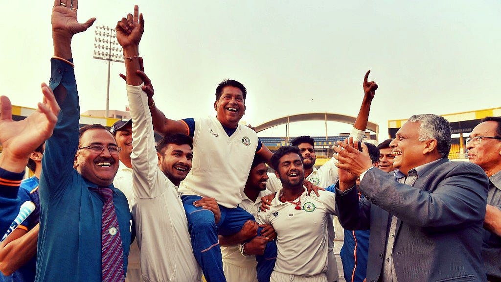 Vidarbha players celebrate with their coach Chandrakant Pandit after winning the Ranji Trophy final cricket match against Delhi by 9 wickets.