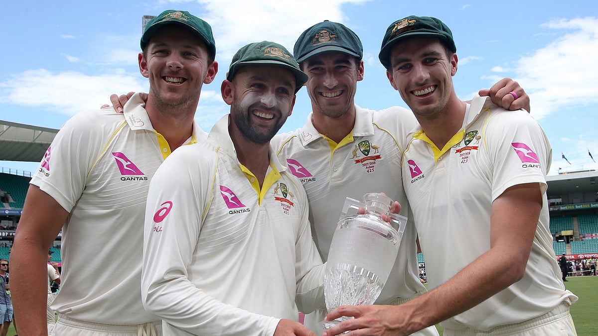 Australian bowlers Josh Hazlewood, left, Nathan Lyon, Mitchell Starc, second right, and Pat Cummins, right, pose with the Ashes trophy.