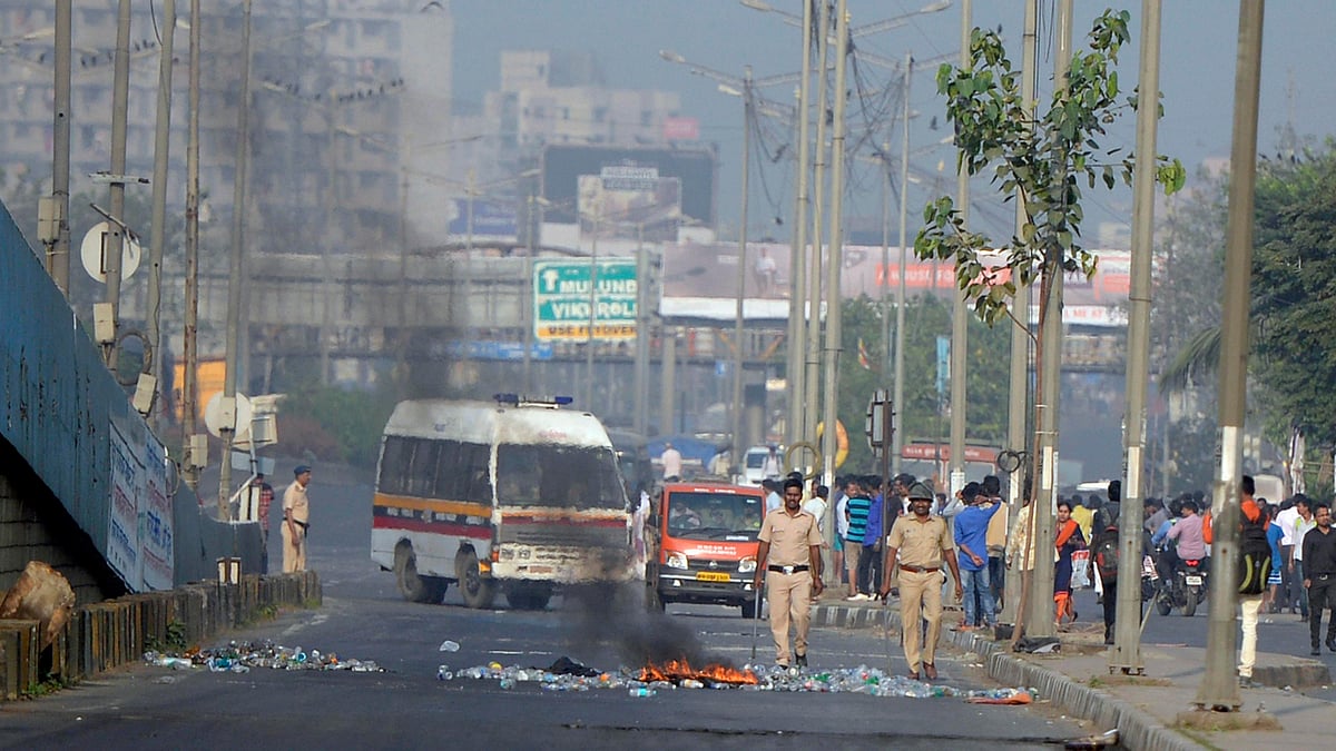 Policemen try to control the situation after a violent protest by the Dalits over Bhima Koregaon violence, in Mumbai