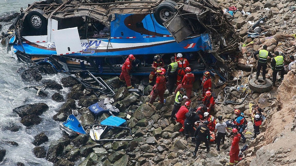 An injured man is transported over water from a bus that fell off a cliff after it was hit by a tractor-trailer rig