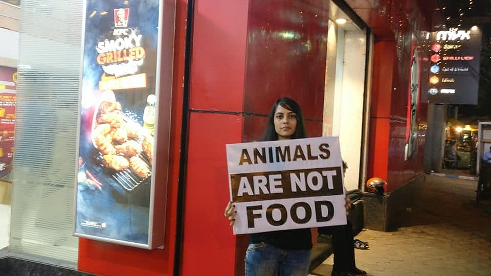 A volunteer holding a placard during the protest in front of KFC, Park Street in Kolkata.