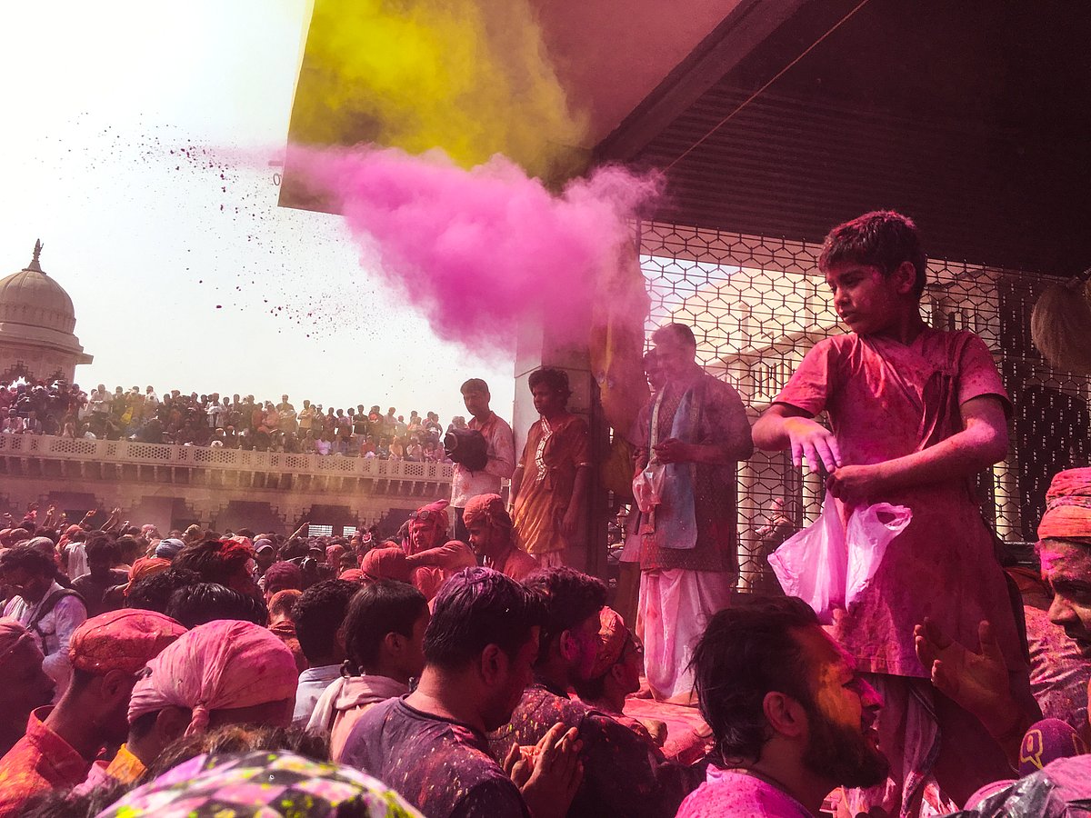 A child brahmin participates as a priest and colors the devotees in the Nand temple in Nandgaon.