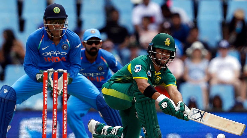 JP Duminy plays a sweep shot as MS Dhoni looks on.