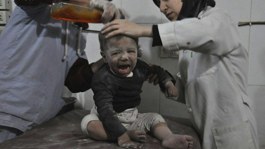 Syrian paramedics treat a child who was wounded during airstrikes and shelling by Syrian government forces, at a makeshift hospital, in Ghouta.