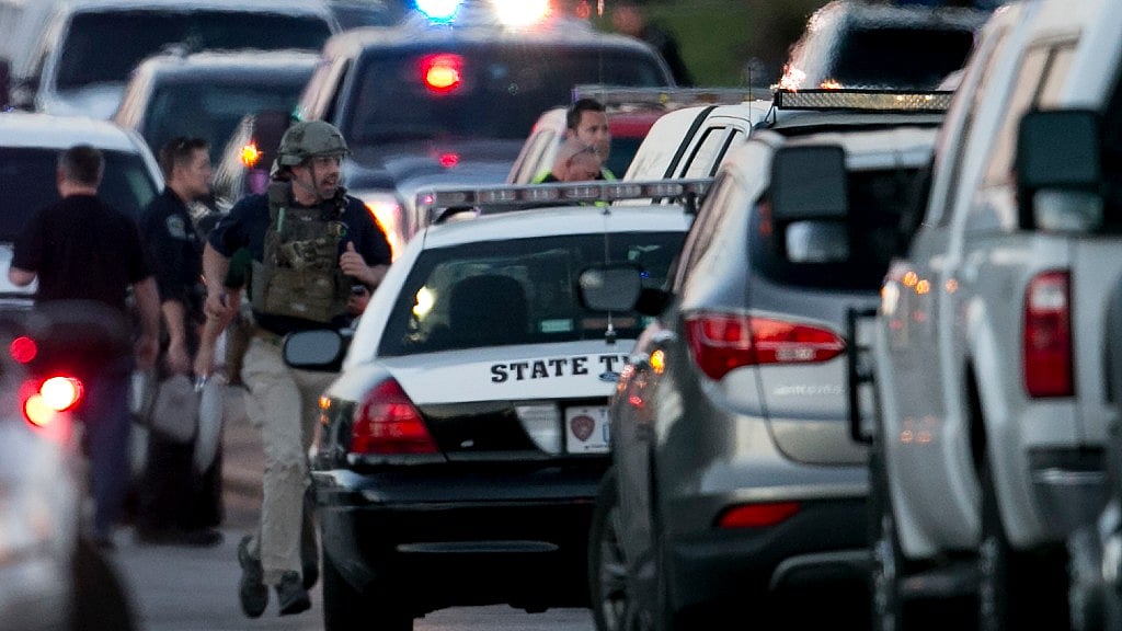 A law enforcement officer runs on Brodie Lane in Austin, Texas, moments after an explosion on Tuesday, 20 March.
