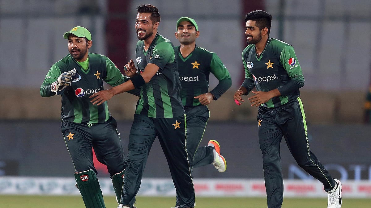 Pakistani pacer Mohammad Amir (centre) celebrates with teammates after taking the wicket of West Indies batsman Andre Fletcher during the 1st T20 match at National stadium in Karachi.