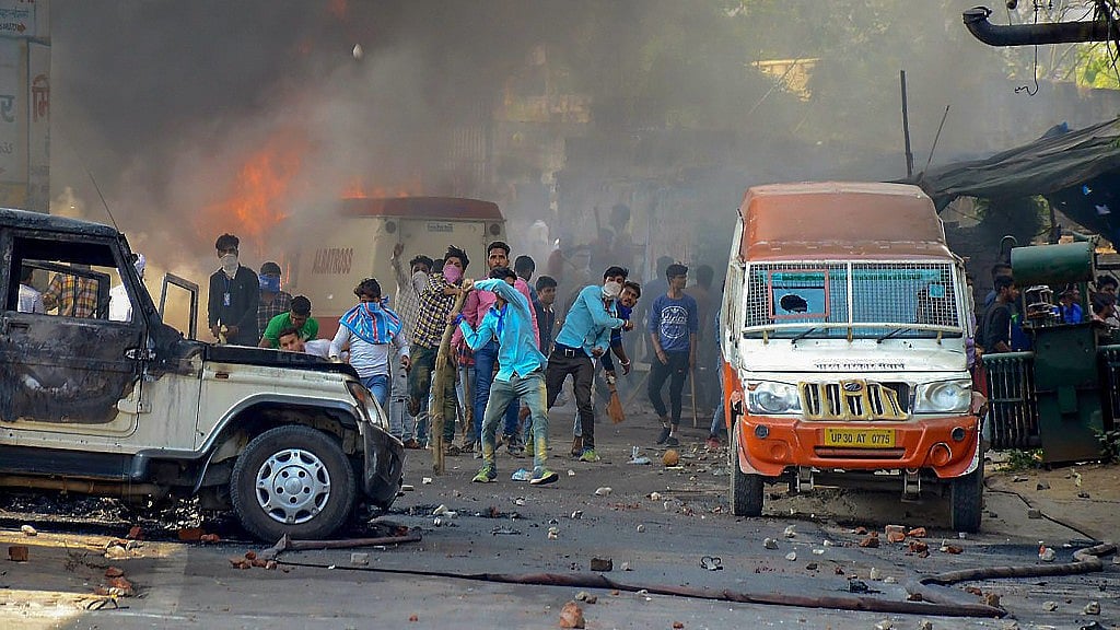 Protestors hurl brickbats as smoke billows out of burning cars during Bharat Bandh against the alleged dilution of Scheduled Castes/Scheduled Tribes act, in Muzzaffarnagar on Monday.