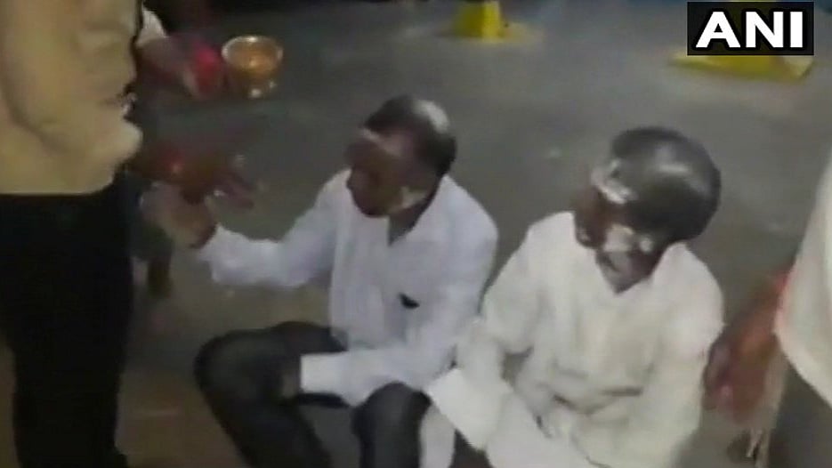 The video shows the two pastors sitting on the floor of the temple while a man smears their faces with ash.