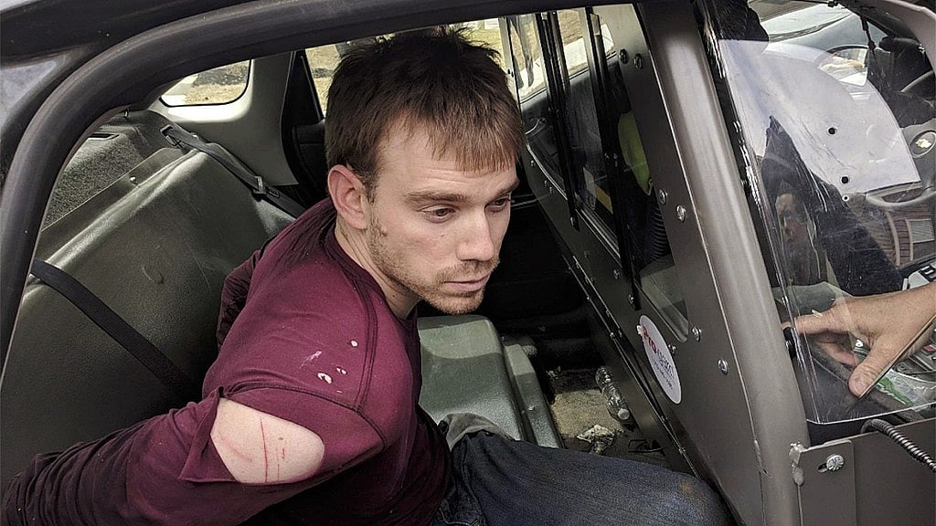 At the time of arrest, suspect Travis Reinking was looking disheveled, was seen wearing a torn red shirt, dirty blue jeans, and had scratches on his shoulder.