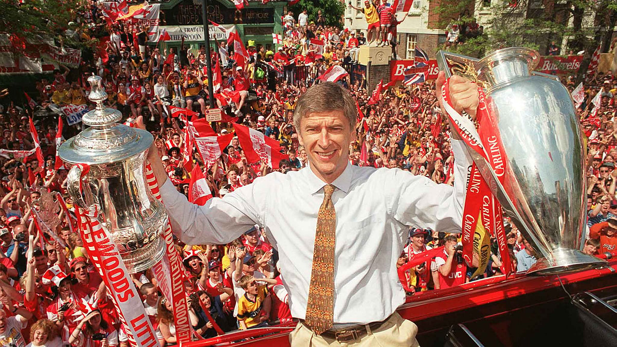 17 May 1998: Arsenal’s French manager Arsene Wenger holds both the League and the FA Cup trophies at a victory parade in London May 17. 