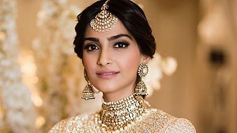 Sonam Kapoor makes a stunning bride in an ivory and gold lehenga by Abu Jani Sandeep Khosla.