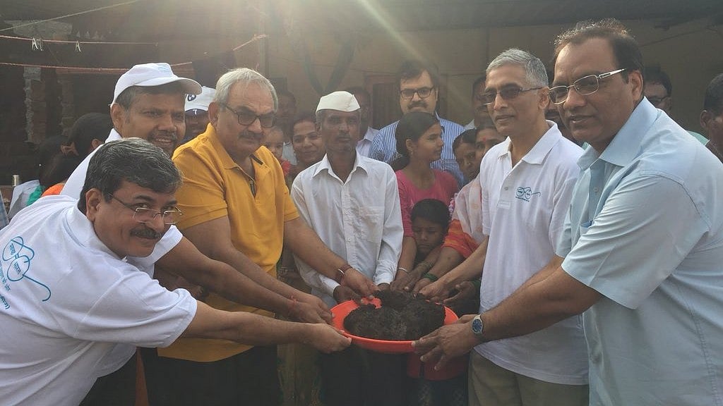CAG Rajiv Mehrishi (in yellow) emptied out a twin-pit toilet in rural Maharashtra in a bid to break sanitation taboos.
