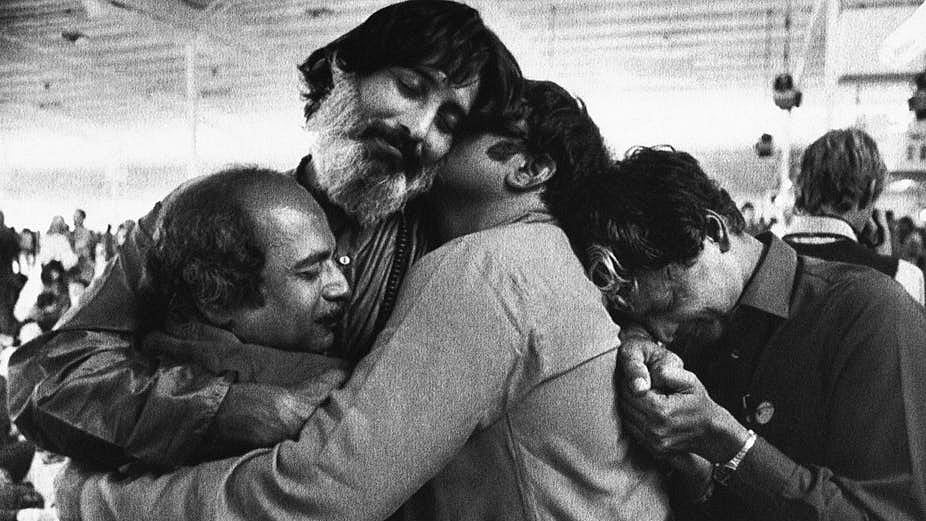 Followers of the Bhagwan Shree Rajneesh embrace during a meditation session at Rajneeshpuram. 