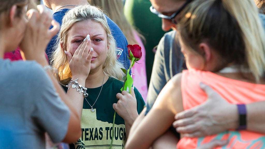 A woman wipes away tears during a prayer vigil following a shooting at Santa Fe High School in Santa Fe, Texas, on Friday, May 18 2018.