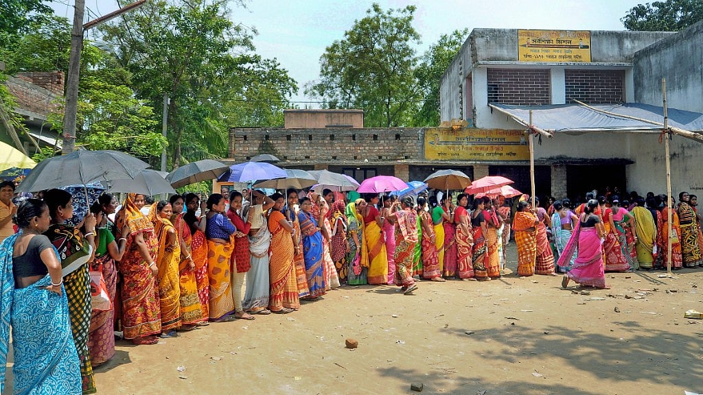 Women stand in a queue to cast their vote for panchayat election at Shantipur polling station in Nadia district of West Bengal on Monday, 14 May. 