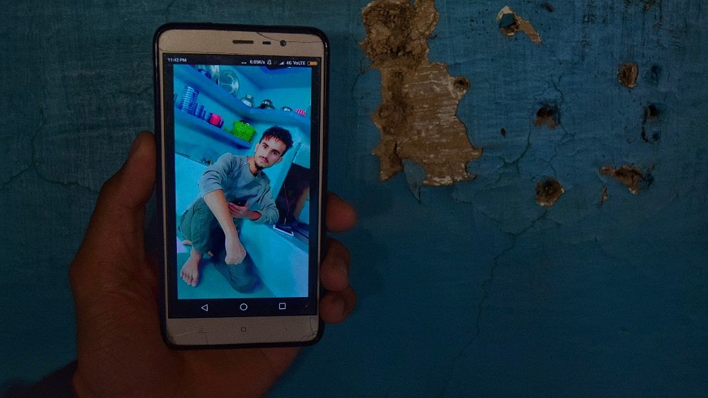 Amir’s cousin displaying his photograph clicked by his sister in their kitchen.