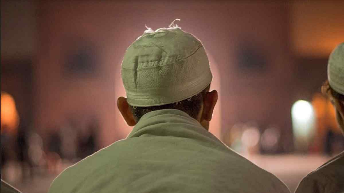 A man sits at Jama Masjid.