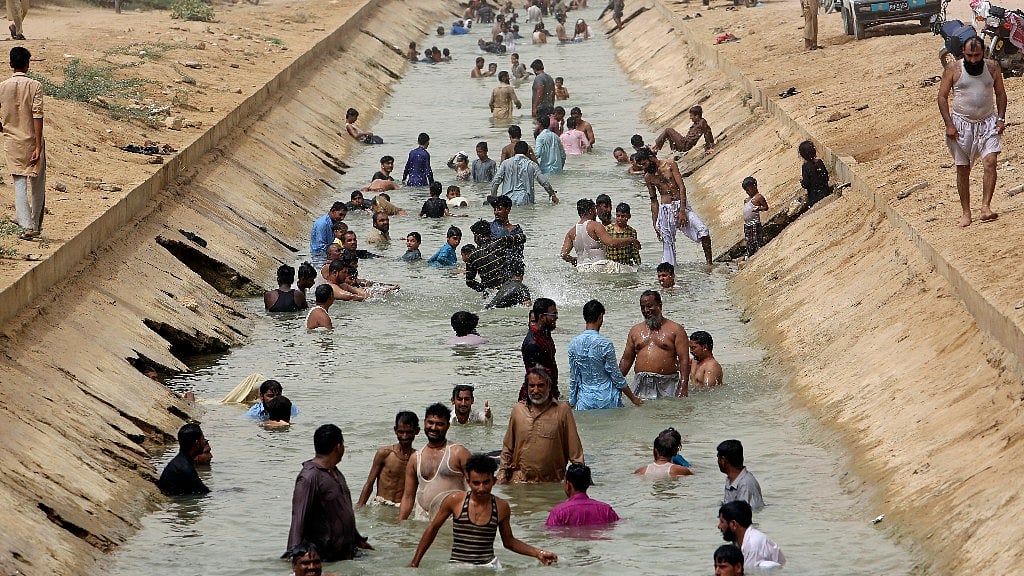People cool themselves off in a canal as temperature reached 44 C (111 F) in Karachi, Pakistan on 30 May 2018. 