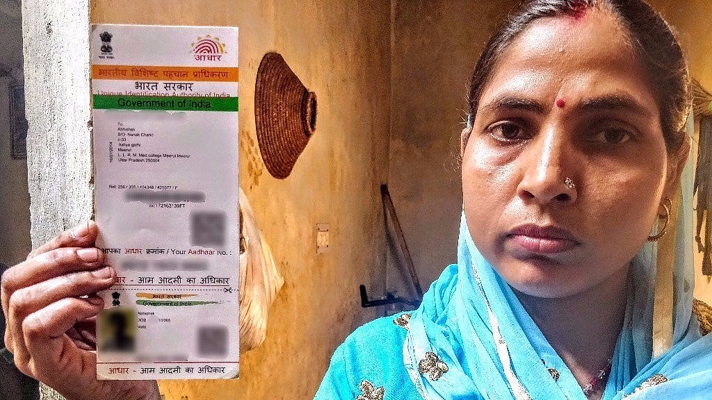 Abhishek’s mother Sundari holds up her son’s Aadhaar card with the year of birth as 2006.&nbsp;
