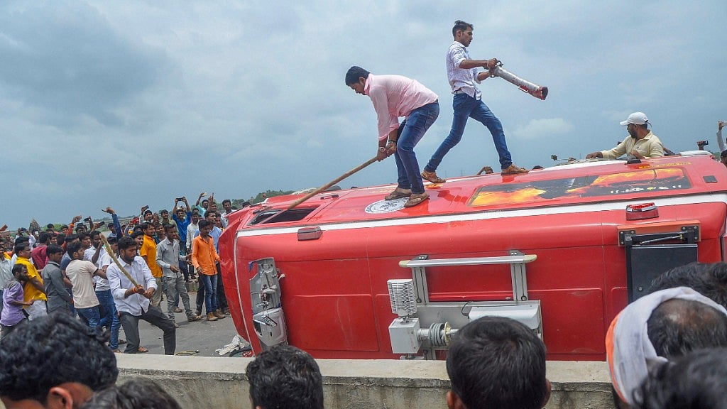 Pro-reservation outfits of Maratha community burn a vehicle after a clash with the police personnel in Kaygaon village at Aurangabad on 24 July.