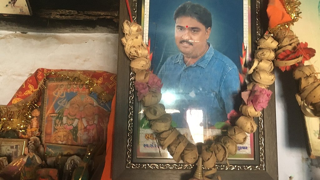 A picture of diamond polisher Bharatbhai Rathod who committed suicide last year hangs at his home in Damrala village in Bhavnagar, India, 31 January 2018. 