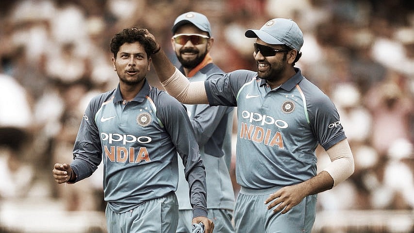 Kuldeep Yadav celebrates a wicket with Rohit Sharma as Virat Kohli looks on.