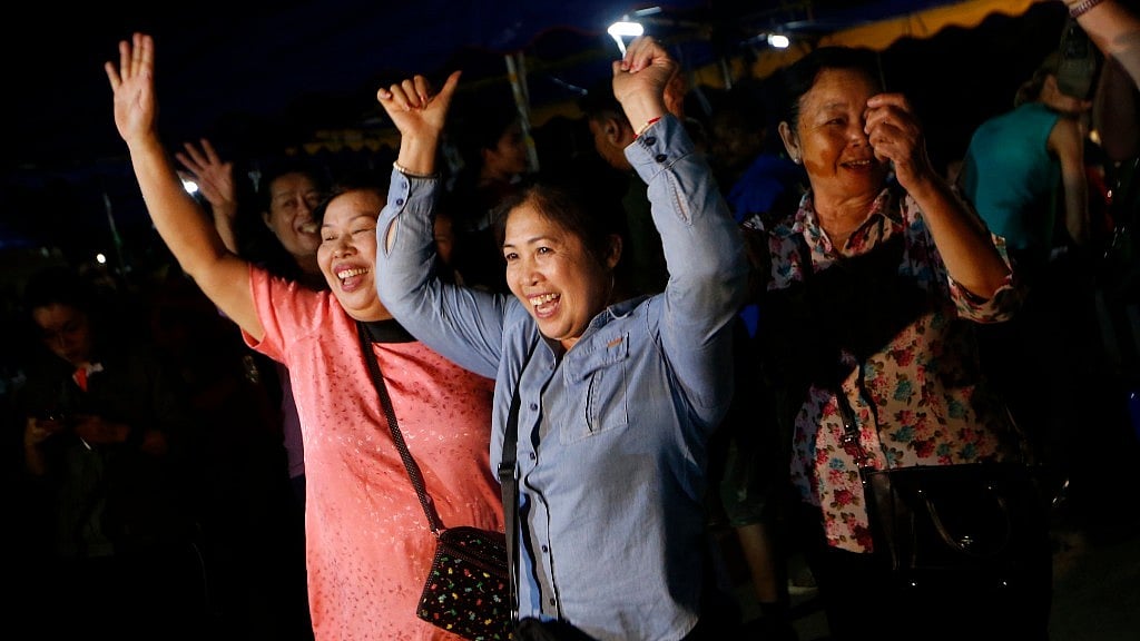 People celebrate after divers evacuated 12 boys and their coach, who had been trapped in a cave since 23 June. 