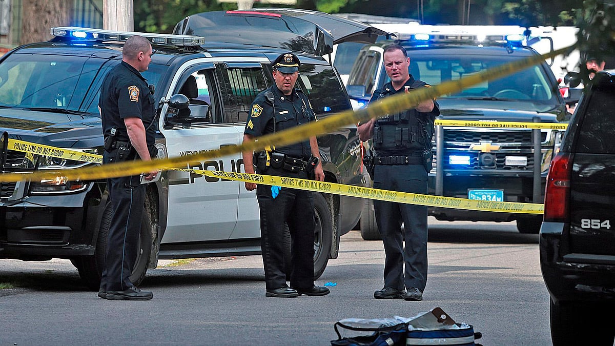 Officers work at the scene where a Weymouth police officer was shot and critically wounded while in a foot chase with a suspect following a vehicle crash on Sunday, 15 July 15.