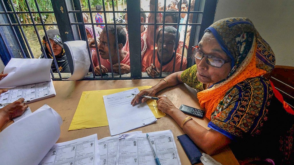  People wait in a queue to check their names on the final draft of the NRC after it was released, at an NRC Seva Kendra in Morigaon on 30 July.&nbsp;