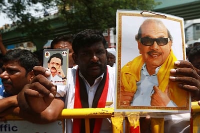 Chennai: A man holding a portrait of  DMK President M. Karunanidhi and DMK working president M.K. Stalin outside the Kauvery Hospital where Karunanidhi is admitted, in Chennai, on July 30, 2018. (Photo: IANS)