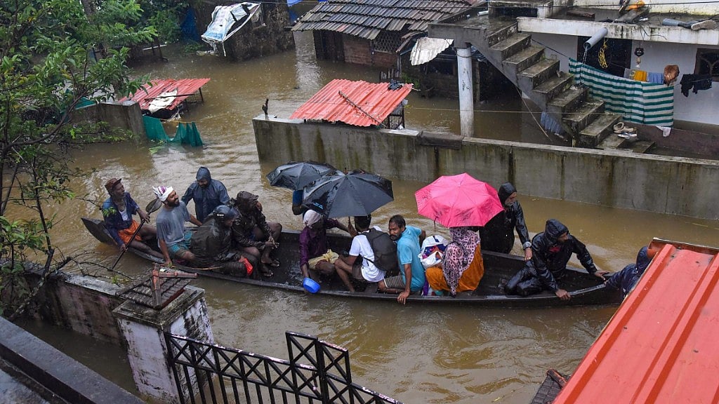 Rescue officials assist villagers out of a flooded area following heavy monsoon rainfall, near Kochi on Wednesday, Aug 15, 2018