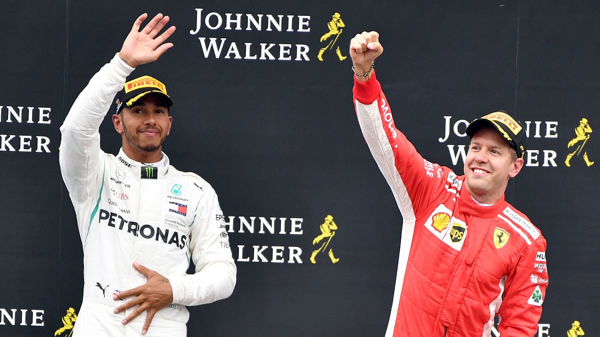 Ferrari driver Sebastian Vettel of Germany, right, jubilates on the podium after winning the Belgian Formula One Grand Prix.