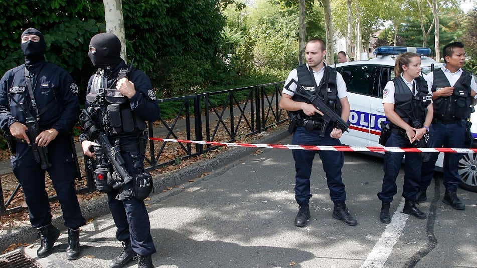 French hooded police officers guard the area with other police officers after a knife attack in Trappes, west of Paris.