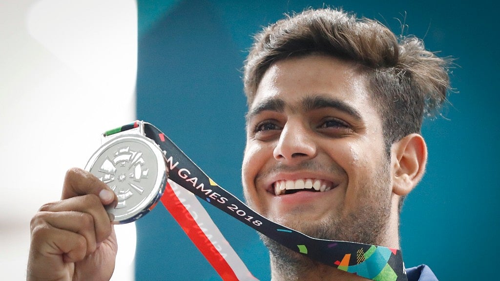 India’s silver medalist Lakshay holds his medal aloft on the podium after the trap men shooting event.
