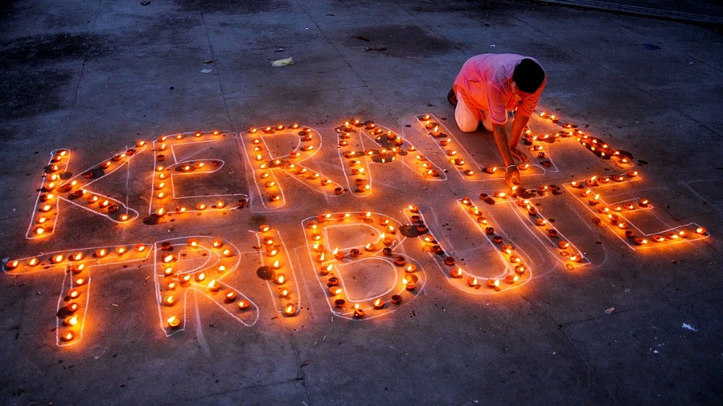 A man lights lamps to pay tribute to Kerala flood victims, in Amritsar.